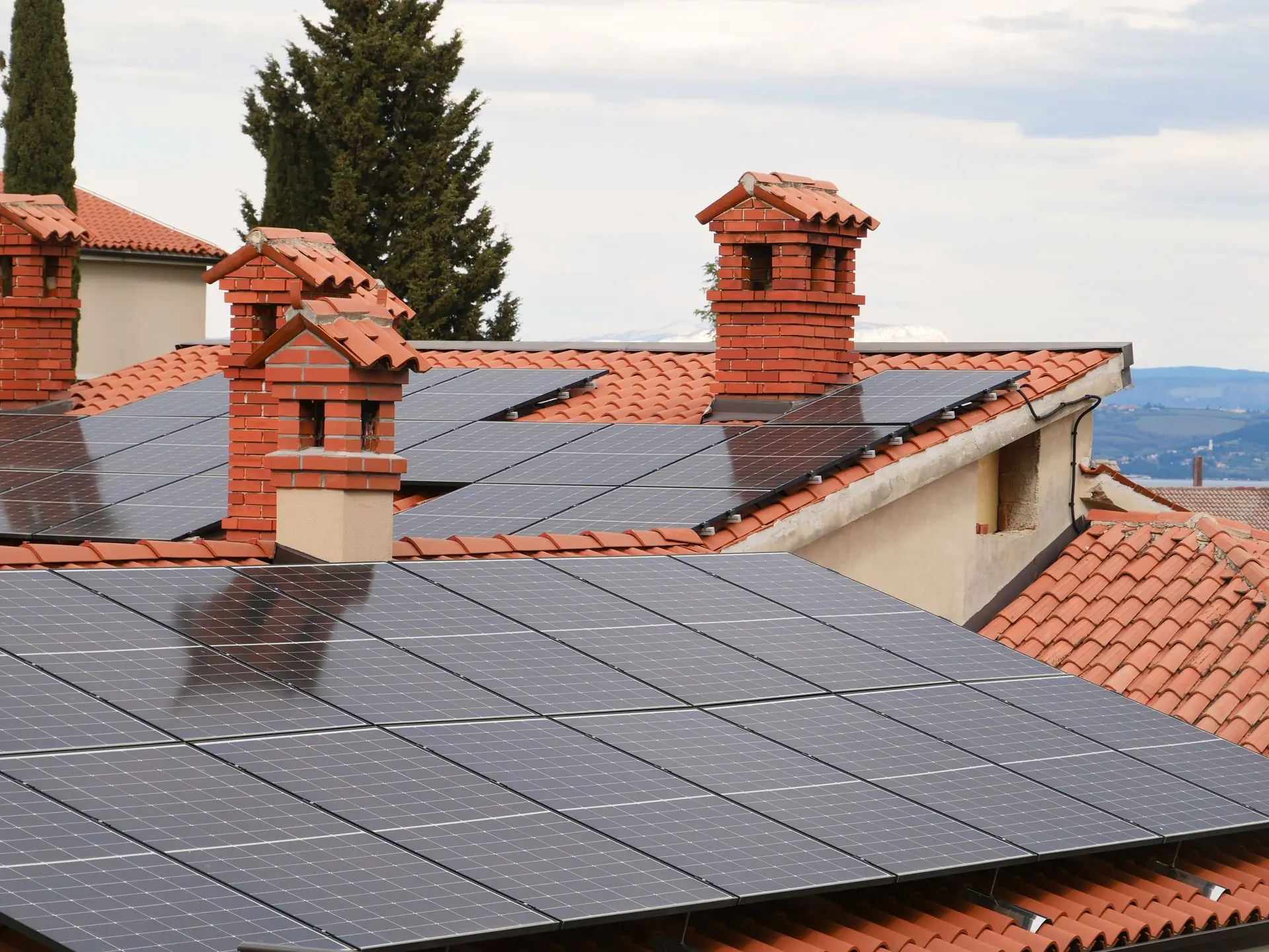 Rows of solar panels installed across a tiled residential roof under bright sky - Cairns City Electrics, Cairns