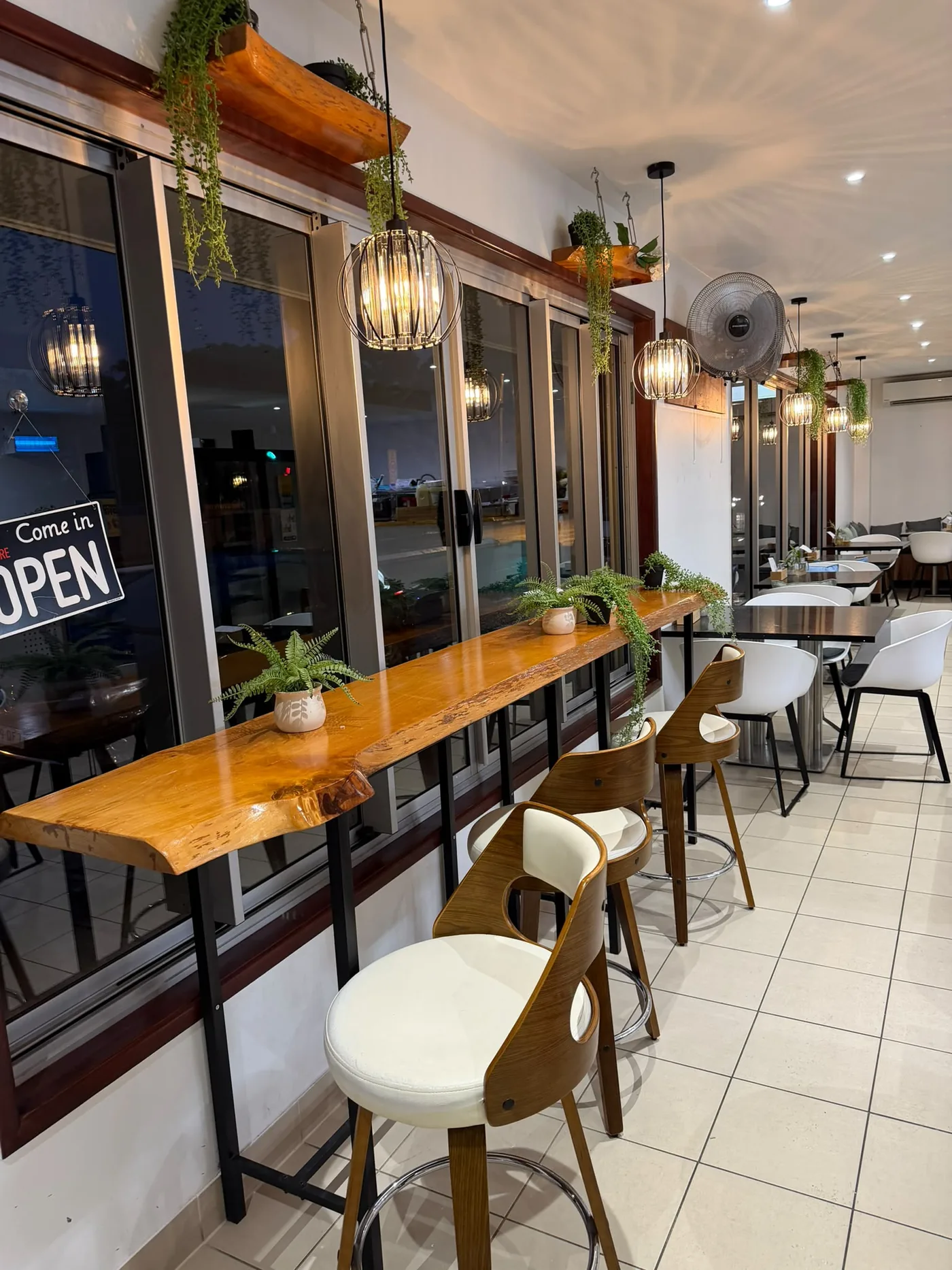 Completed cafe bar fit-out with installed pendant lights above a timber bench - Cairns City Electrics, Cairns